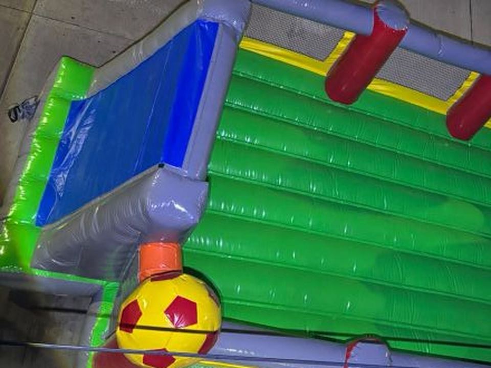 Detalle de la cancha de fútbol inflable con balones y portería