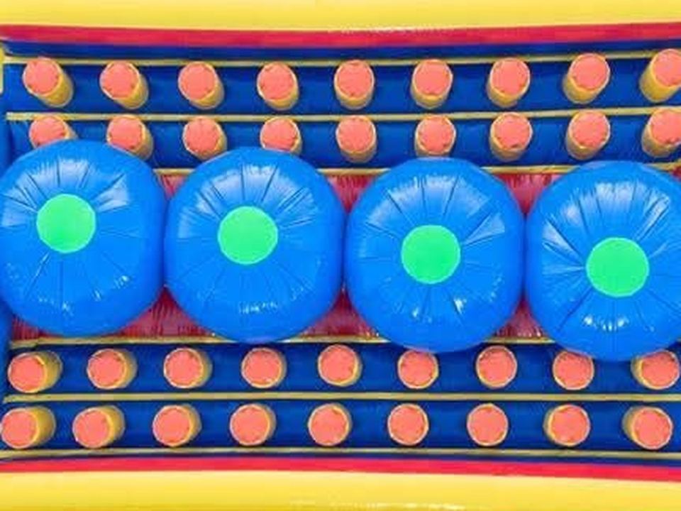 Vista cenital del inflable resbalón con cuatro burbujas azules y obstáculos naranjas